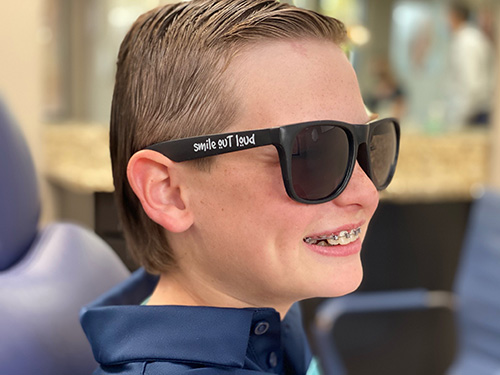 A young boy wearing sunglasses | Harwell & Cook Orthodontics