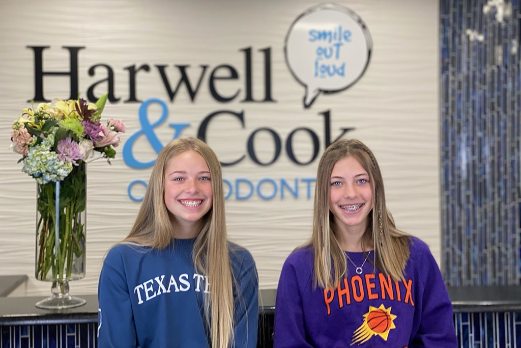 Two young women in front of the practice wall | Harwell & Cook Orthodontics
