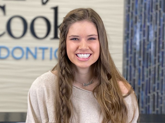 A smiling woman with long brown hair. | Harwell & Cook Orthodontics