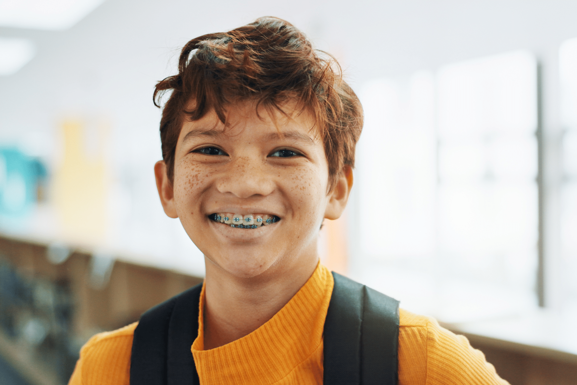 Smiling boy wearing braces and a backpack